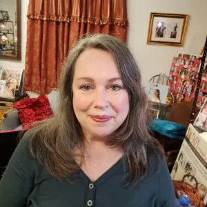 A woman sitting in a room with a lot of pictures.