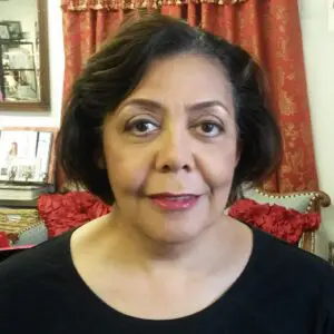 A woman in a black shirt is standing in front of a room.