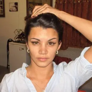 A woman putting her hair up in a bun.