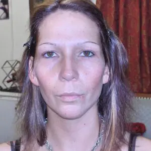 A woman posing in front of a mirror.