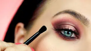 Close-up of a woman applying eye makeup.