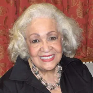 An older woman wearing a black shirt and necklace.