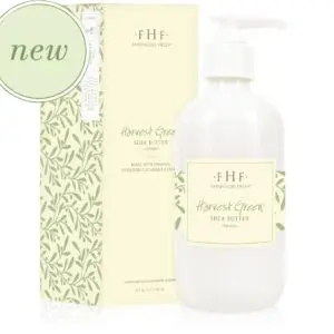 A bottle of body lotion with green leaves and a box next to it.