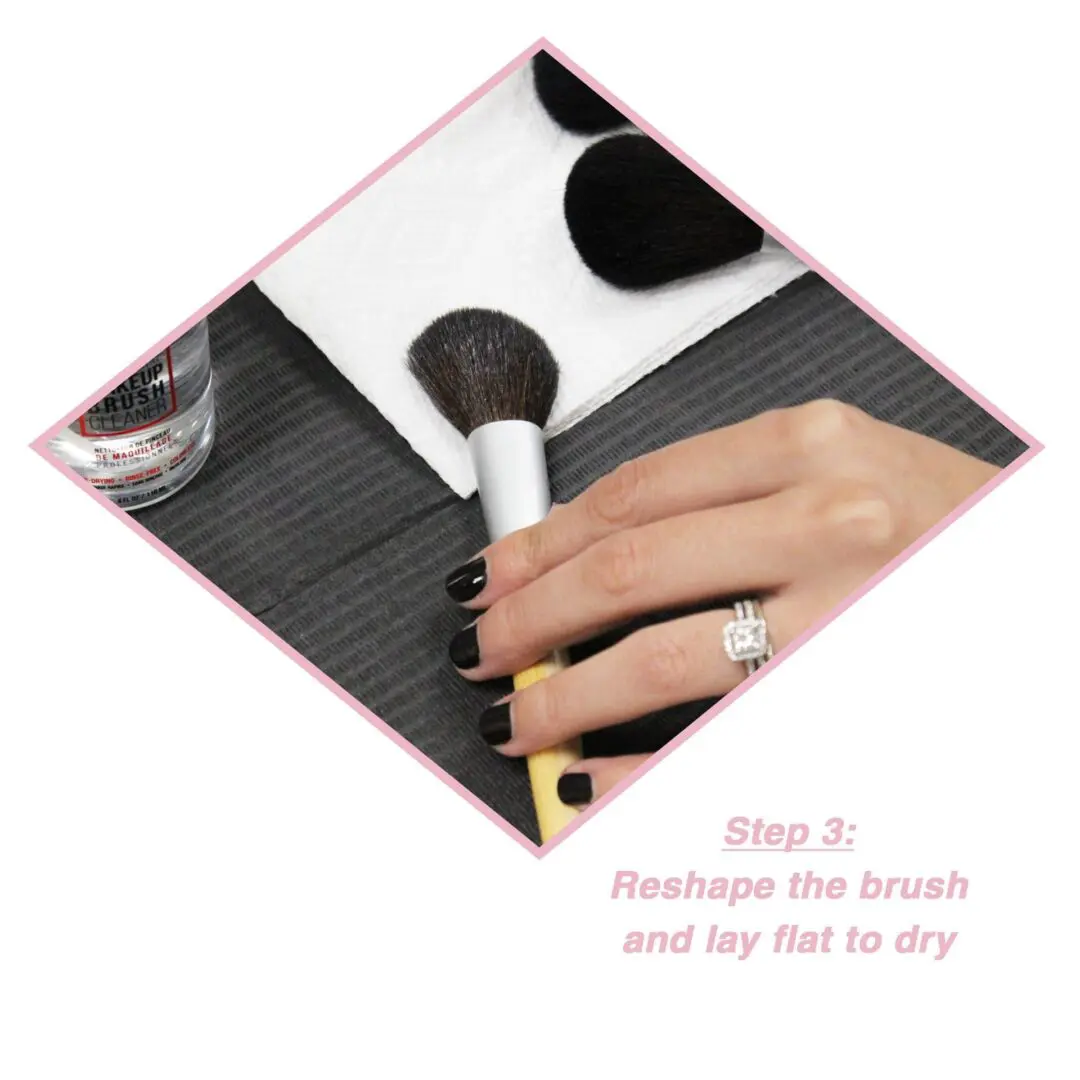 A woman is using a makeup brush to apply makeup.