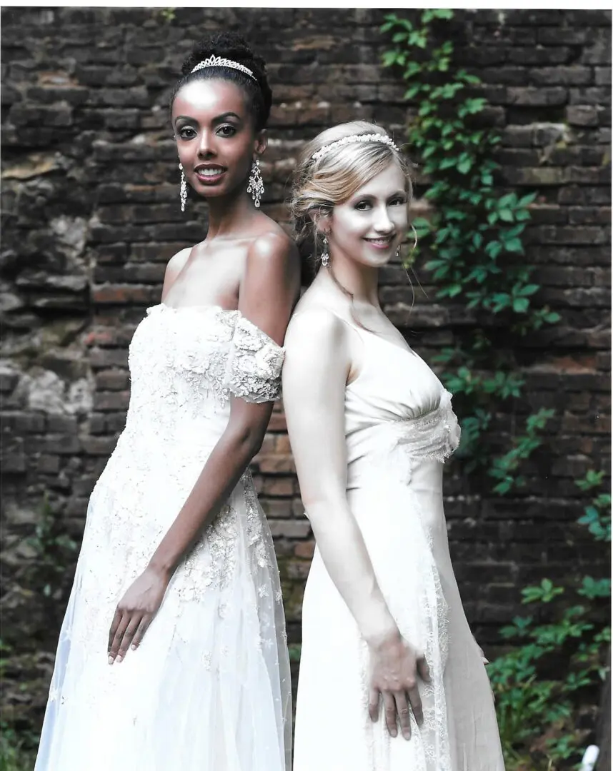 Two brides in white wedding gowns.