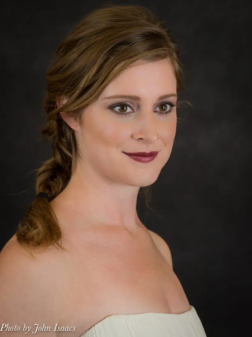 Woman with brown hair and makeup.