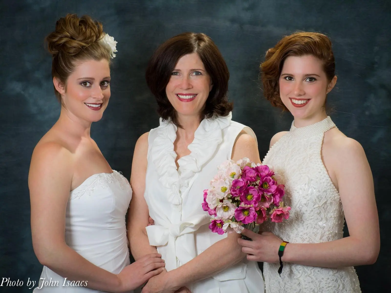 Mother and two daughters in wedding attire.