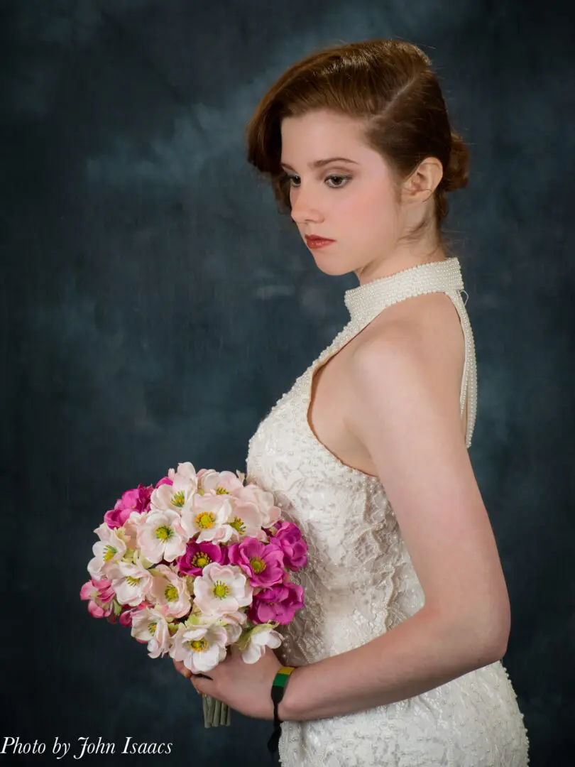 Bride in lace dress holding bouquet.
