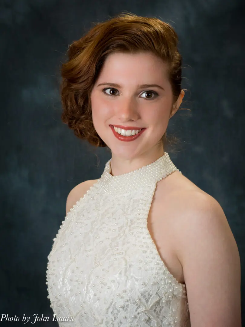 Smiling woman in a pearl dress.