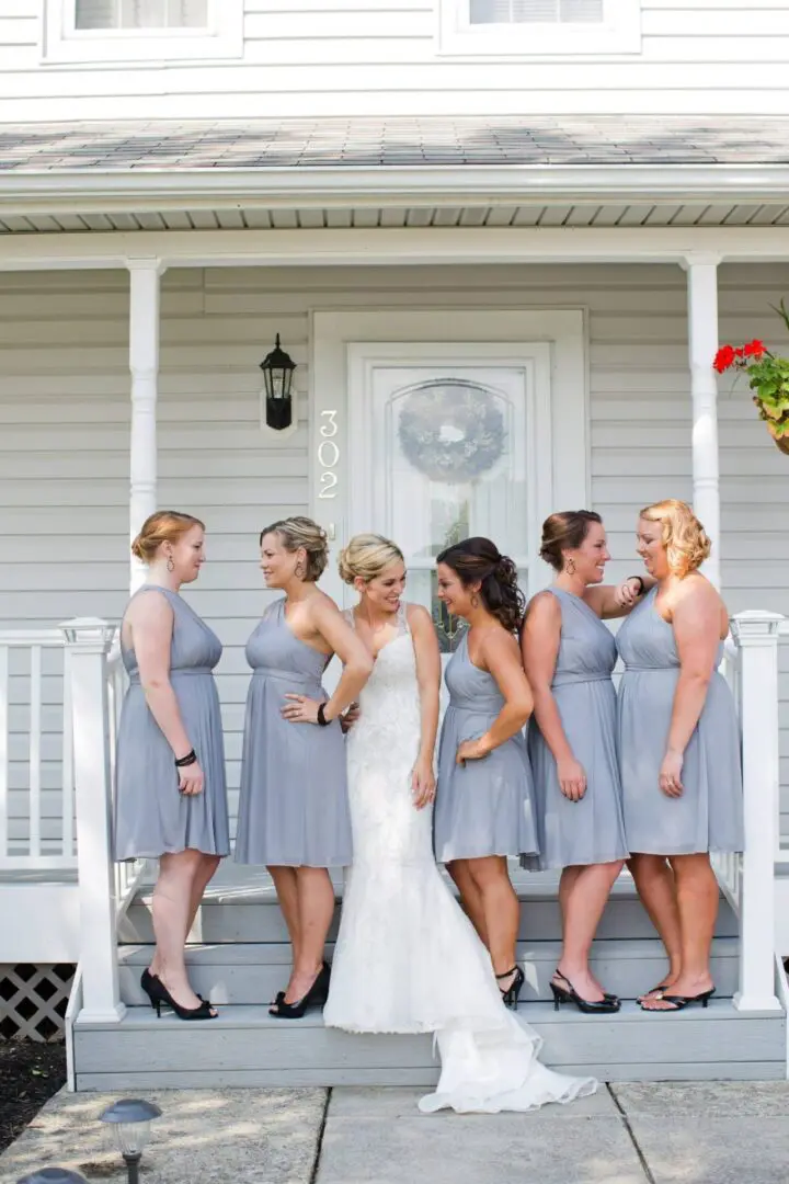 Bride with bridesmaids on porch steps.
