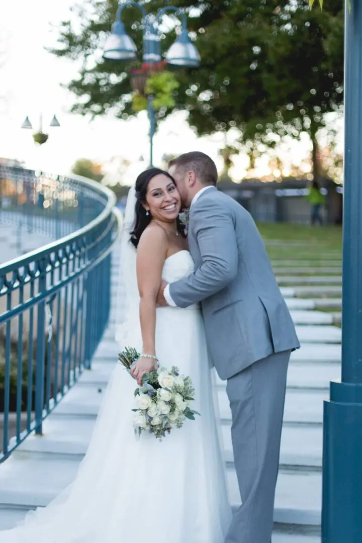 Bride and groom embracing on steps.