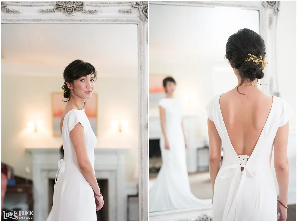 Bride in white wedding dress, looking in mirror.