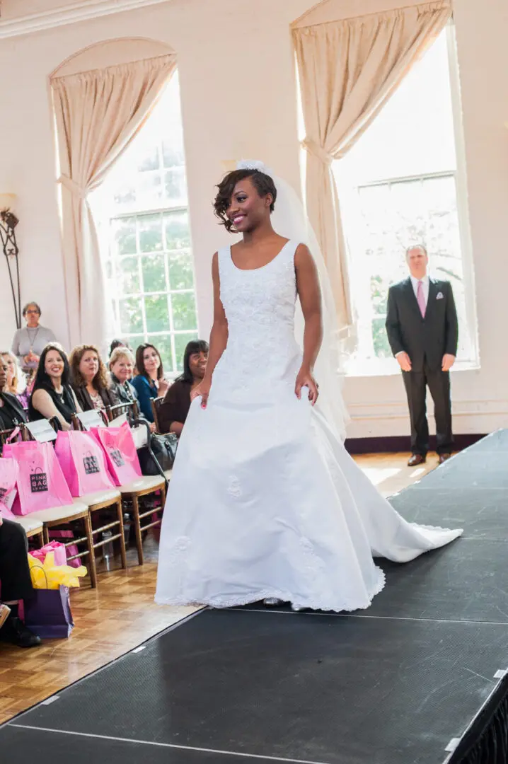 Bride in white wedding gown on runway.