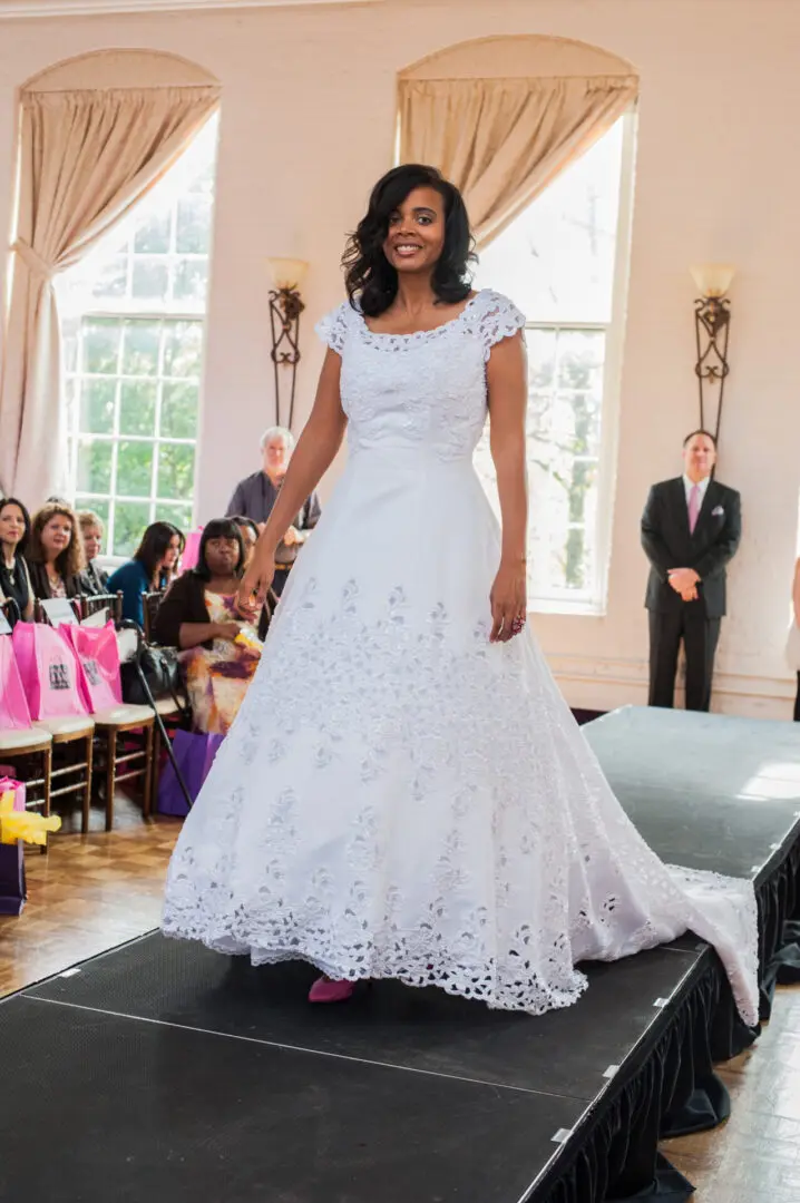 Bride in lace wedding gown on runway.
