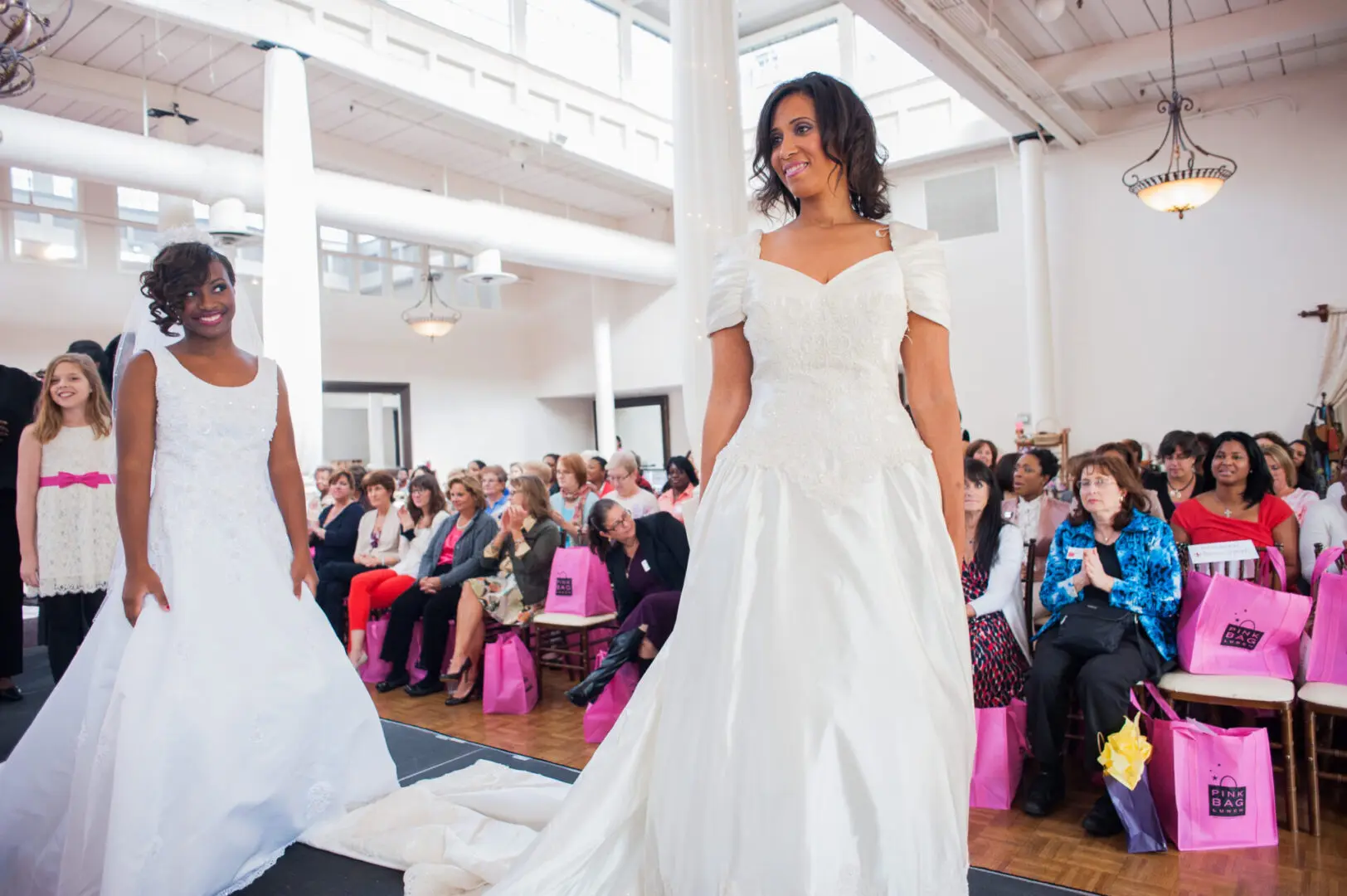 Two brides modeling wedding gowns.