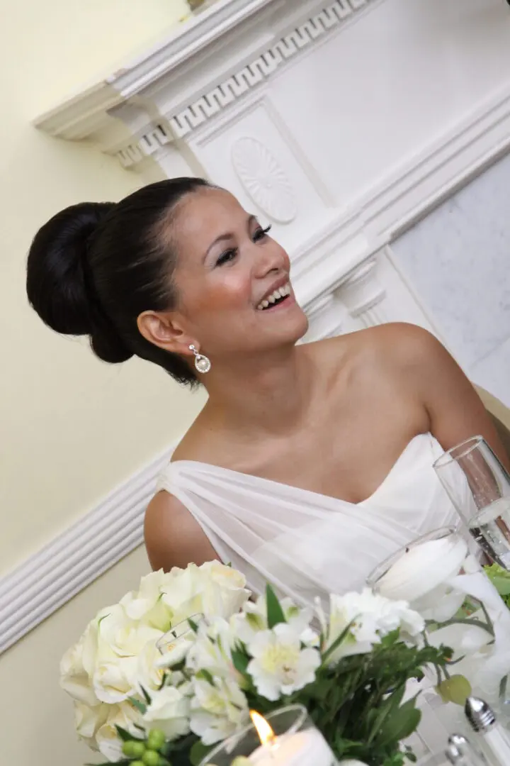 Bride smiling, white dress, wedding flowers.