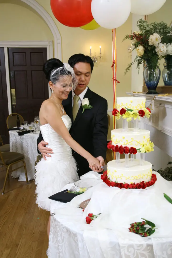 A Bride and groom cutting wedding cake.