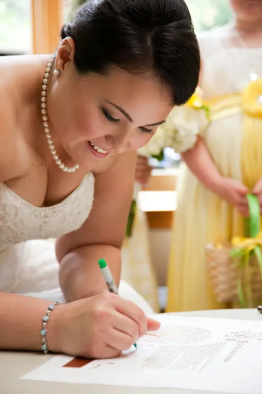Bride signing wedding document.