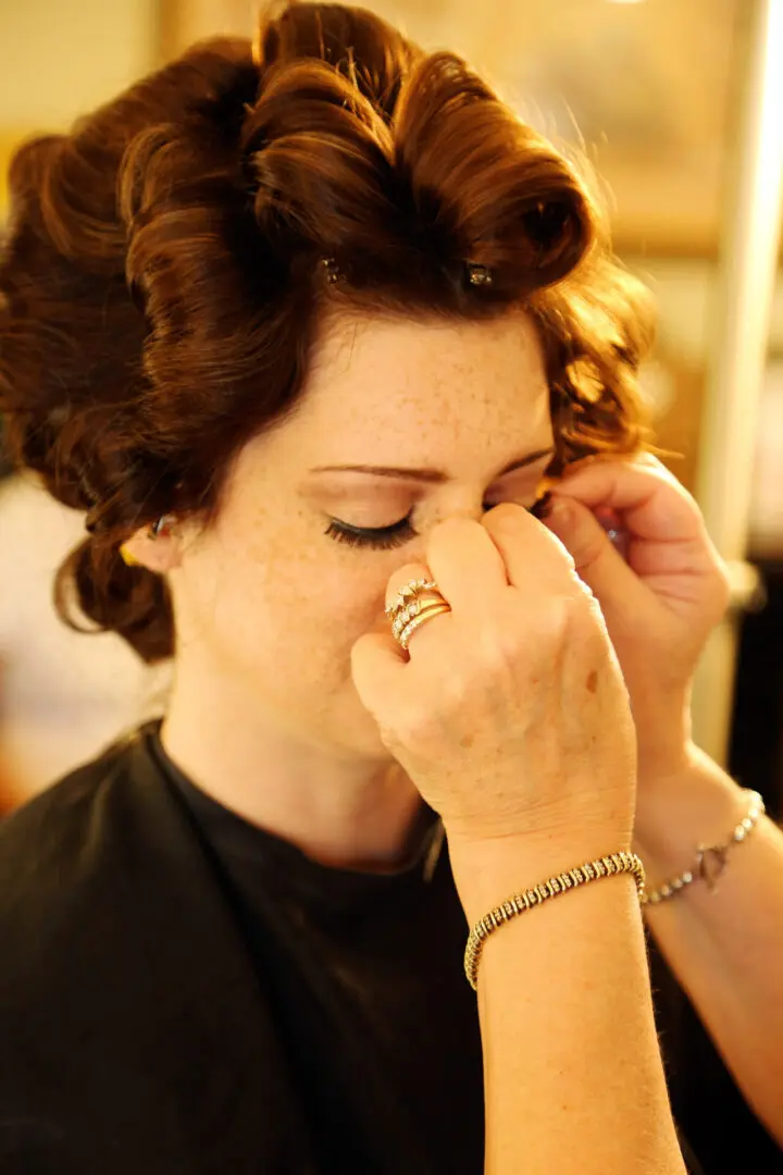 A Woman getting her hair styled.