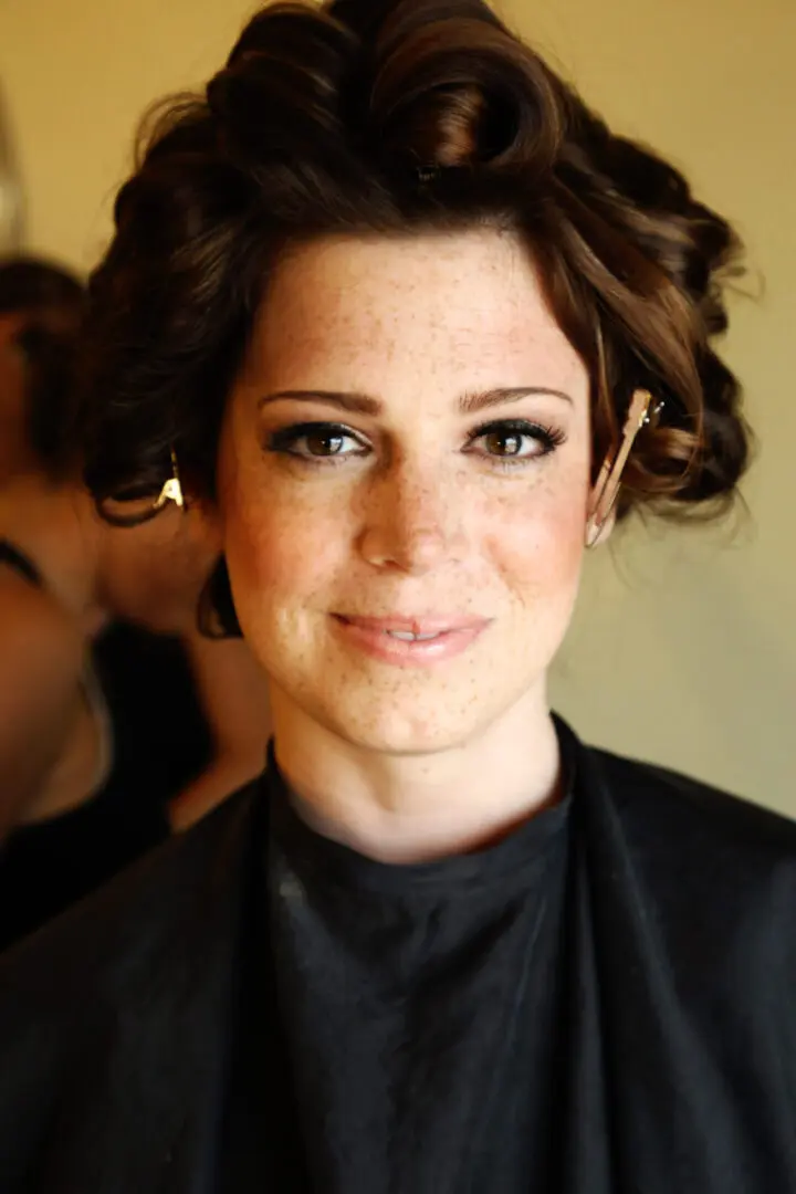 Woman with freckles and styled hair.
