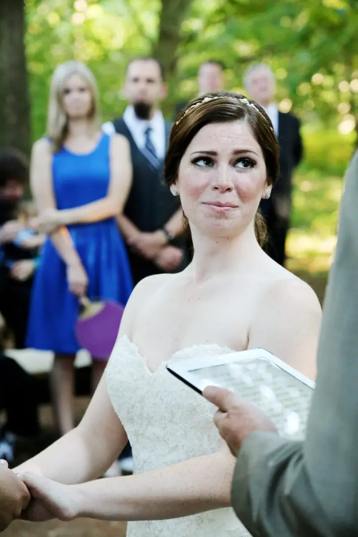 Bride holding vows at outdoor wedding.