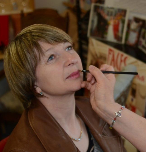 Young makeup artist applying Lipstick