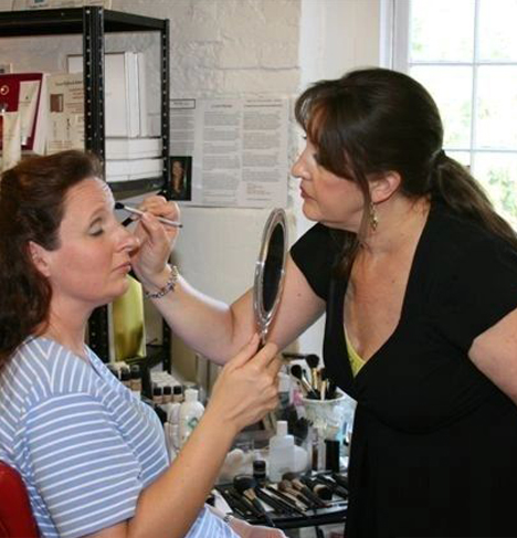 Woman putting makeup on another woman