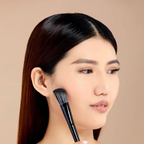 Woman applying makeup with brush.