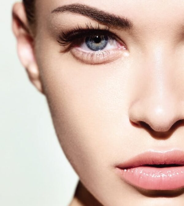 A close up of a woman's face with blue eyes.