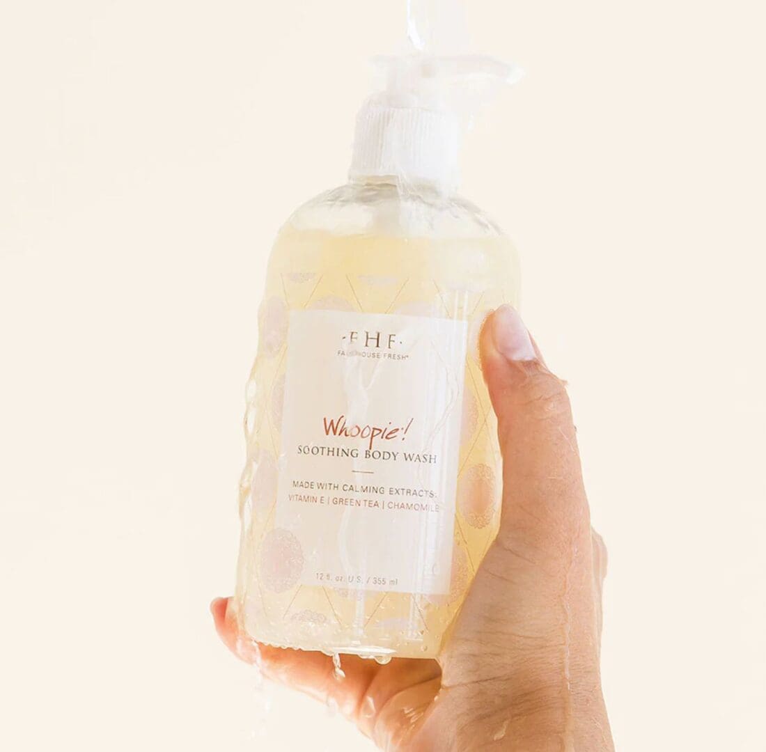 A hand holding a bottle of Farmhouse Fresh Whoopie Cream Body Wash and Bubble Bath.
