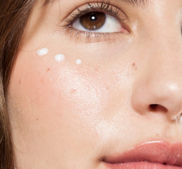 A close up of a woman's face with cream on it.