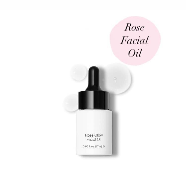 A bottle of rose facial oil with a white background.