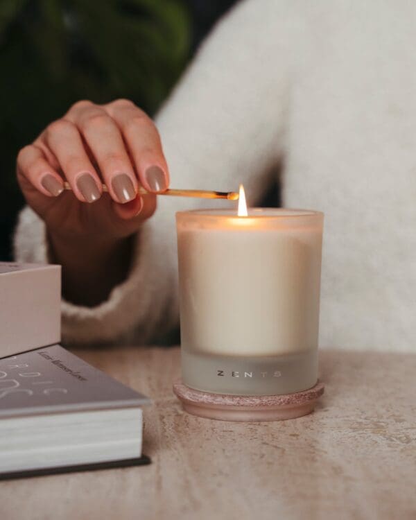 Hand lighting a scented candle.