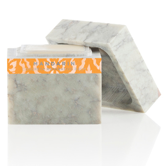 A white marble soap box with an orange label.