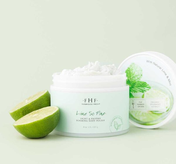 A jar of FHF Lime So Fine Foaming Body Polish with a slice of lime next to it.
